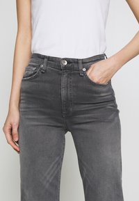 Gray denim jeans with a classic fit, five-pocket design, subtle fading, and a silver button closure at the waist. Smooth texture.
