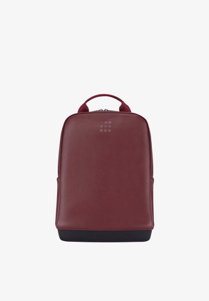 Zaino rettangolare color bordeaux con manico superiore, superficie liscia, logo discreto vicino alla cerniera e base nera su sfondo bianco.