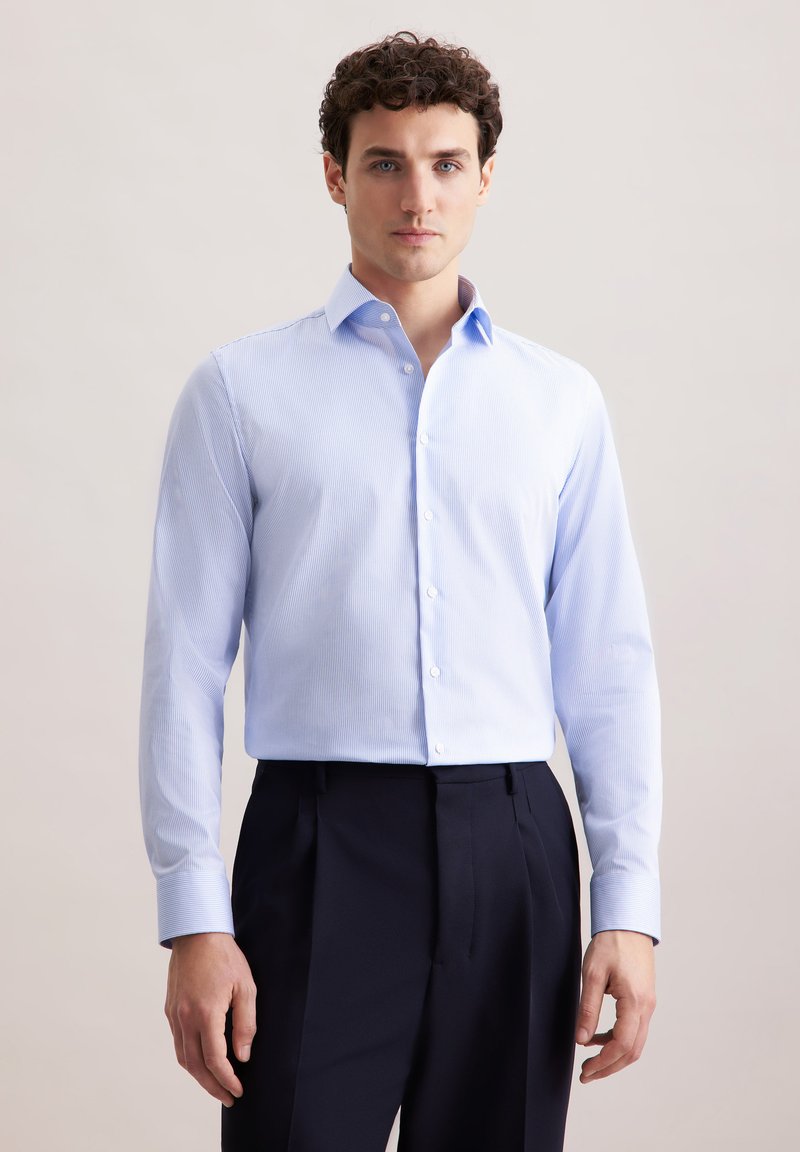 Camicia a righe blu chiaro con colletto a punta, maniche lunghe e chiusura con bottoni, abbinata a pantaloni scuri, per un aspetto elegante.