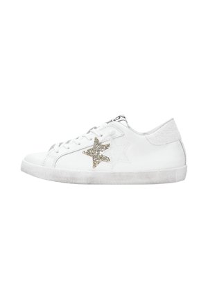 Sneaker bianca a bassa top con lacci bianchi, decorazioni di stelle glitterate oro e bianche sui lati e suola leggermente usurata.