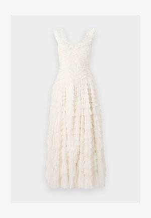 Robe blanche mi-longue avec un design texturé et volanté. Elle possède de larges bretelles et un corsage ajusté, avec des volants qui tombent le long de la jupe.