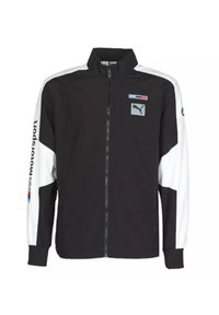 Chaqueta deportiva en blanco y negro con cremallera frontal completa, cuello alto, bolsillos laterales y el logo de Puma en el pecho y la manga.