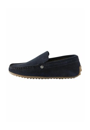 Mocassini in suede blu navy con punta arrotondata, cuciture decorative e suola in gomma con texture rialzate per una maggiore aderenza. Inclusa una pannello elastico laterale.