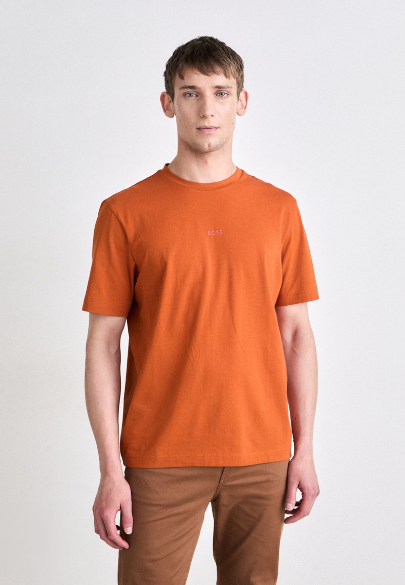 Kortsleeved, rundhalset t-skjorte i ensfarget oransje, laget av myk bomull, med diskret "BOSS"-logo i midten.