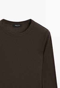 Maglione a maniche lunghe marrone scuro con collo a giro, realizzato in tessuto morbido e liscio. Presenta un design semplice con un'etichetta visibile all'altezza del collo.