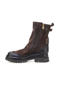 Botín de cuero marrón oscuro con cremallera lateral, suela gruesa negra, asa de tirón y detalle de remaches en la parte posterior.