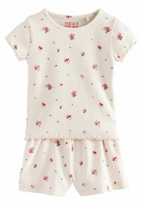 Kort blomstret pyjamasæt i cremefarvet, med små pink og røde blomster, ribbet tekstur, bølget kant og korte ærmer med matchende shorts.