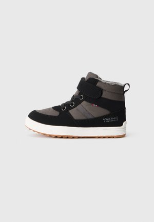 Bottines pour enfants, noires avec des panneaux gris, dotées d'une sangle Velcro, d'accents en dentelle et d'une semelle texturée pour une meilleure adhérence. Doublure chaude visible en haut.