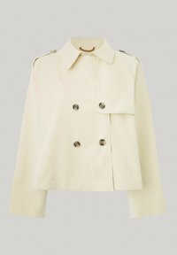 Chaqueta de color crema, de doble botonadura, con un cuello puntiagudo, mangas largas y botones grandes, con una longitud por encima de la cadera y una textura suave.