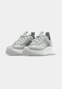 Ανοιχτό γκρι αθλητικά παπούτσια κατασκευασμένα από λεία υλικά με υφή στη σόλα,  διαθέτουν λευκά κορδόνια, επενδυμένη γλώσσα και λεπτομέρεια λογότυπου στο πλάι.