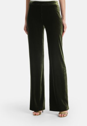 Pantalones de terciopelo verde de pierna ancha con una textura suave y una cinturilla alta, combinados con elegantes tacones dorados con tiras. Líneas limpias y un diseño elegante.