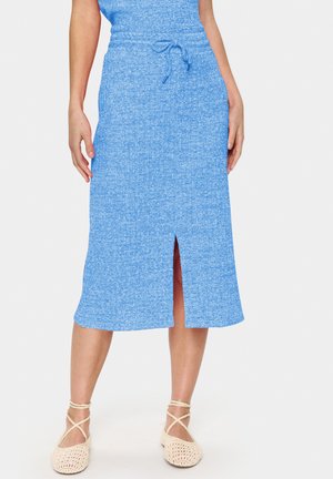 Helles blau, knielanger Rock aus strukturiertem Stoff mit Zugband in der Taille und einem Schlitz vorne. Kombiniert mit beigefarbenen, im Häkelstil gehaltenen Schuhen.