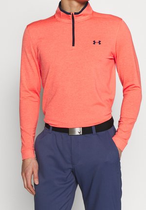 Langarm-Pullover in leuchtendem Koralle mit hohem Kragen und halbem Reißverschluss. Das Material hat eine glatte Textur, akzentuiert mit einem navy-blauen Logo und Gürtel.