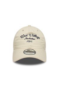 Beige baseball cap med mørkeblå brodert tekst "West Village Manhattan N.Y.C." Har en justerbar stropp og rund logo-patch på skyggen.