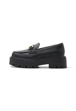 Black chunky loafer with thick treaded sole, gold buckle detail on top, low heel, and smooth leather finish, shown in side profile.