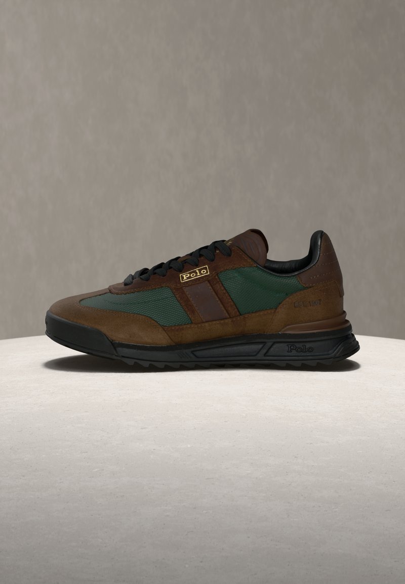 Hnědé a zelené tenisky z broušené kůže a síťoviny, s černými tkaničkami a značkovým logem. Podešev z pryže s vzorkem pro lepší přilnavost.