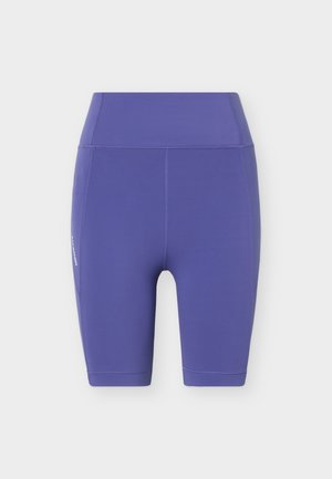 Lilla atletikshorts med høj talje og knælængde, flatlock-sømme og diskret mærkelogo på venstre side mod en hvid baggrund.