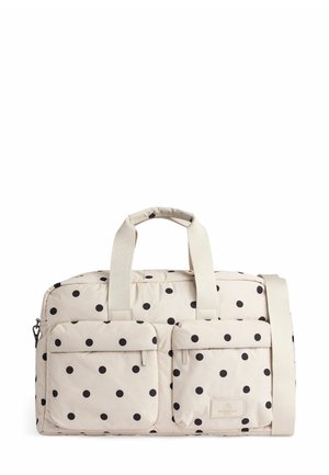 Duffle taske med polka dots i cremefarvet med sorte prikker; har to frontlommer, robuste håndtag og en aftagelig skulderrem.