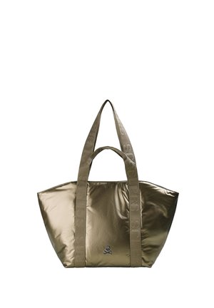 Bolsa tote de bronce brillante con asas anchas de tela y un pequeño emblema de calavera y tibias cruzadas en el centro delantero.