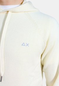 Felpa in maglia beige con tasca frontale, cappuccio con cordino e logo ricamato blu chiaro sul petto. Tessuto morbido con polsini a costine.