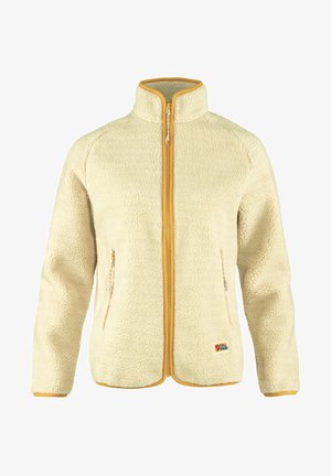 Beige fliisjakker kõrge kraega, kollane tõmblukk ja kontrastne ääristus. Omab küljetaskuid ja logopatchi alumises ees.