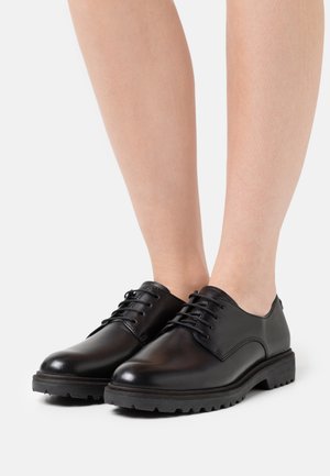 Chaussures habillées en cuir noir avec une finition lisse, un bout rond et un laçage ; dotées d'une semelle en caoutchouc texturée pour une meilleure adhérence et durabilité.