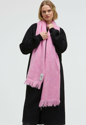 Pink knit scarf with fringed ends, featuring a soft texture. Draped over a black long-sleeve garment, showcasing its vibrant color contrast.