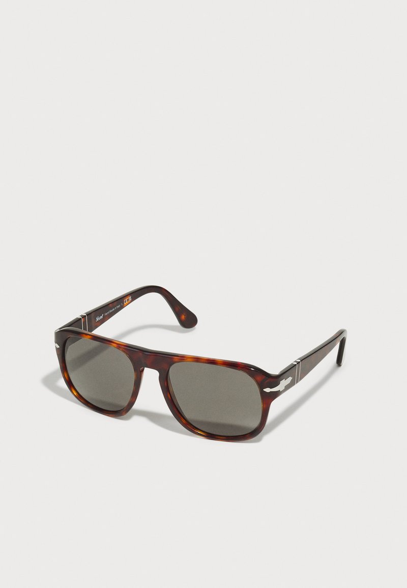 Tortoiseshell sunglasses with dark gray lenses. Square frame design. Silver accents on temples. Smooth finish and sturdy construction.