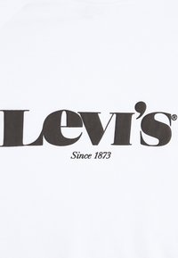 Weißes T-Shirt mit einem großen schwarzen "Levi's"-Logo und dem Text "Seit 1873" in einer klassischen Schriftart. Glatte Textur, Rundhalsausschnitt.