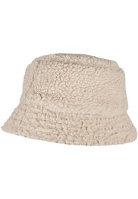 Cremefarvet bucket hat lavet af struktureret, fluffy stof med et blødt udseende. Har en bred, fleksibel skygge og en rund krone.