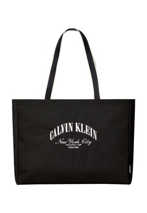 Borsa tote rettangolare nera con manici lunghi neri e bianchi, scritta bianca "Calvin Klein New York City" sul davanti.