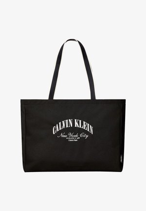 Borsa tote rettangolare nera con manici lunghi neri e bianchi, scritta bianca "Calvin Klein New York City" sul davanti.