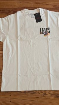 Bijela Levi's majica s malim višebojnim logom na gornjem lijevom dijelu prsiju i crnom Levi's oznakom pričvršćenom blizu ovratnika.
