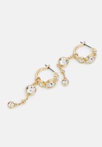 Gold hoop earrings featuring multiple clear gemstones in round settings, with a dangle detail and varying sizes of stones for added dimension.