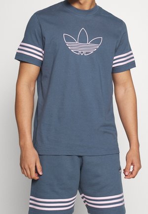 Blauwe katoenen t-shirt met korte mouwen, met een roze omlijning van een logo en twee roze strepen op elke mouw.