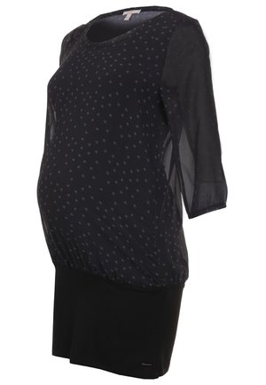 Musta äitiysmekko, jossa on läpikuultavat kolmen neljänneksen hihat ja pieni valkoinen kasvikuvio yläosassa.