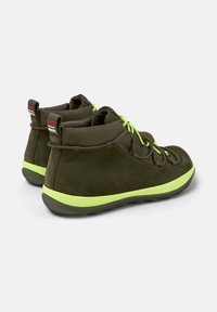 Ciemnozielone trampki typu high-top z limonki akcentami i sznurowadłami, z wyraźną teksturą powierzchni i wyściełanym tyłem dla wsparcia.