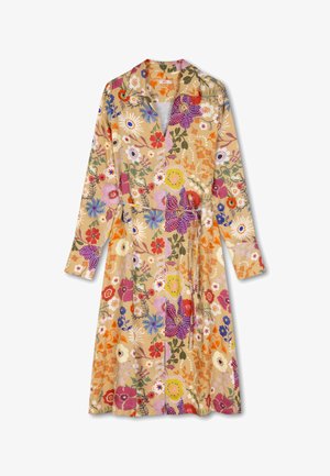 Bloemenrokjurk in beige met lange mouwen. Heeft multicolore bloemen, een riem op de taille en een kraag voor extra detail.