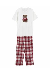 Biały bawełniany t-shirt z nadrukiem brązowego misia. Czerwono-białe, w kratę spodnie piżamowe mają luźny krój i boczne szwy.