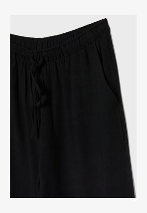 Schwarze Hose mit elastischem Bund und Kordelzug, bietet eine lockere Passform und Seitentaschen. Das Material wirkt weich und leicht.
