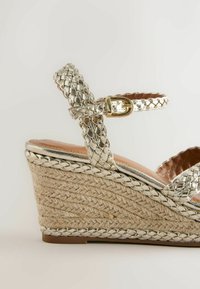 Sandale compensée avec brides métalliques tressées et boucle, dotée d'un talon haut en plate-forme tressée en jute.