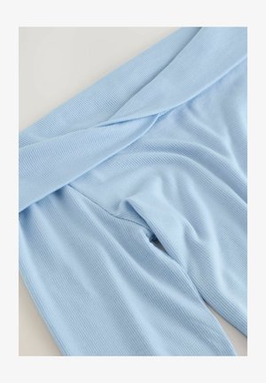 Svetle modrá žebrovaná látka s přehnutým pasem a hladkým povrchem, která předvádí uvolněný střih a jemný elastický efekt.