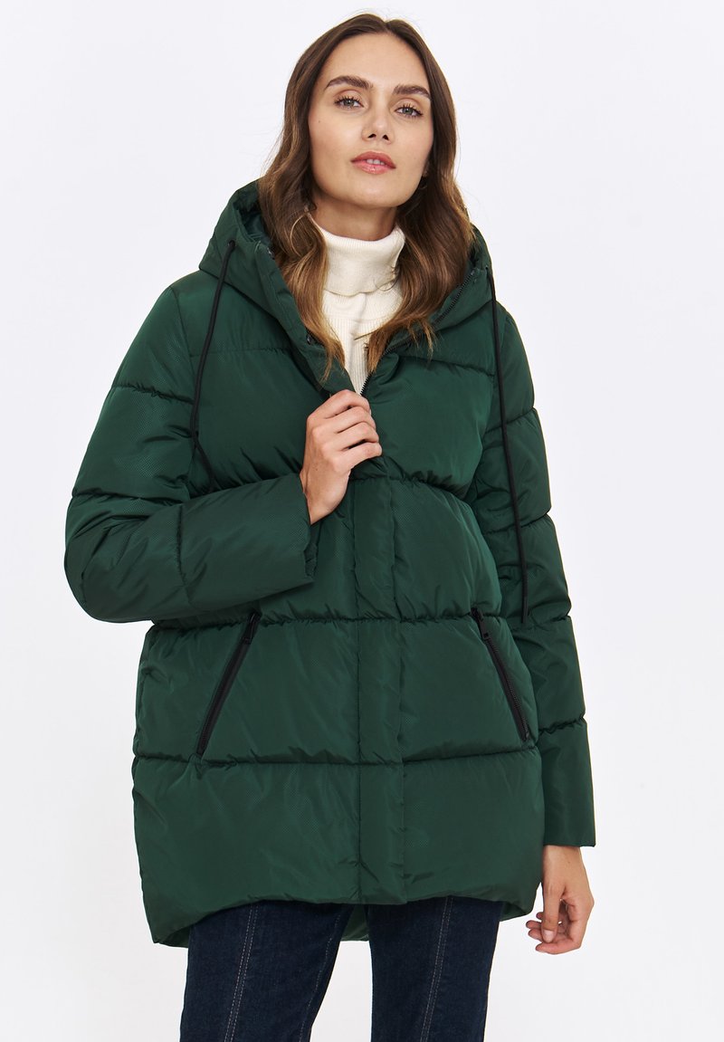 Ocieplana zielona kurtka puchowa z kapturem, zapinana na zamek, z dwoma bocznymi kieszeniami i czarnym wykończeniem na brzegach.