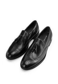 Zapatos de cuero negros con un diseño elegante, que presentan perforaciones decorativas y borlas en la parte delantera. Suela de goma para mayor durabilidad.