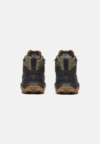 Bottes de randonnée montantes noires et olive avec des panneaux texturés, un col rembourré et des semelles en caoutchouc robustes dotées de motifs de traction.
