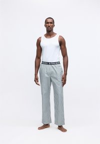 Balts topiņš bez piedurknēm, svītrainas pidžamas bikses zilo un baltā krāsā, elastīga josta ar "BJÖRN BORG" zīmolu, brīvs piegriezums, kokvilnas materiāls.