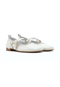Scarpe flat in pelle bianca con fasce incrociate, punta tonda e tacco basso. Presentano due accenti circolari dorati sul lato per la chiusura.