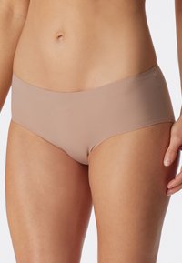 Beige nahtlose Hipster-Unterwäsche mit glatter Textur, niedrigem Design und dezenten Nähte, geeignet für den täglichen Gebrauch.