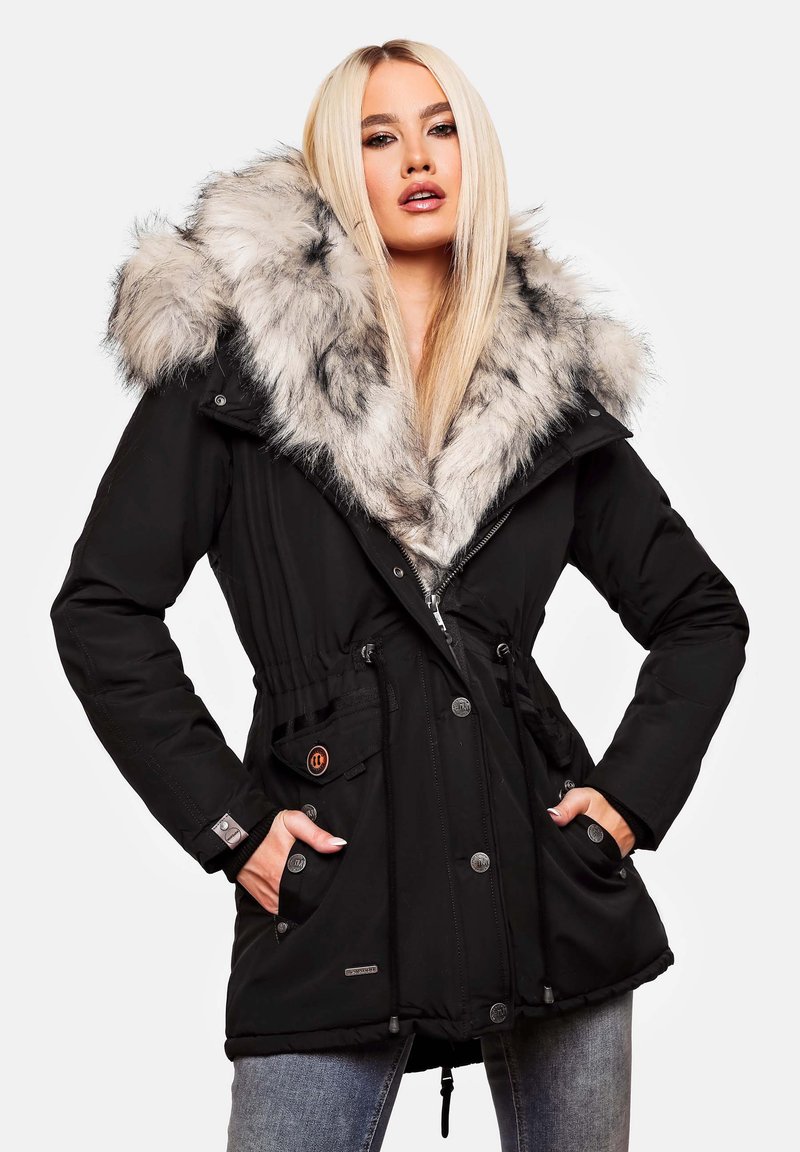 Parka negra con capucha de piel, cintura ajustada y múltiples bolsillos. Presenta una textura suave y detalles de hardware en plata.