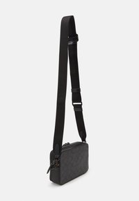 Bolso de hombro negro con exterior texturizado, cierre de cremallera y correa ajustable. Presenta patrones sutiles y acentos de cuero.